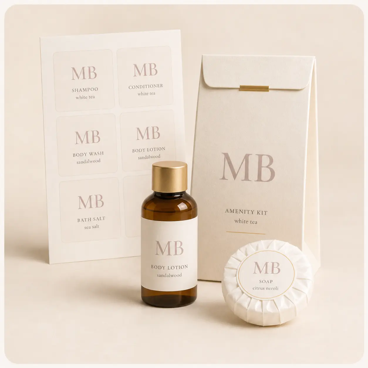 Sheet of custom Mirah Belle amenity labels beside a branded amenity kit sachet, a sandalwood body lotion bottle and a pleated citrus neroli soap